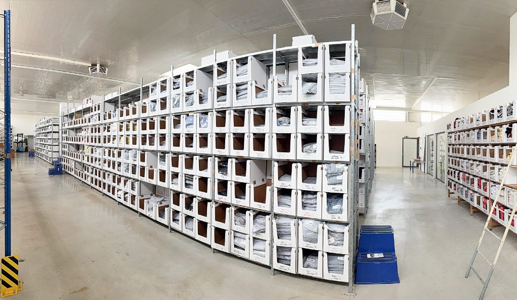 White pick bins on metal shelving in a fulfilment aisle