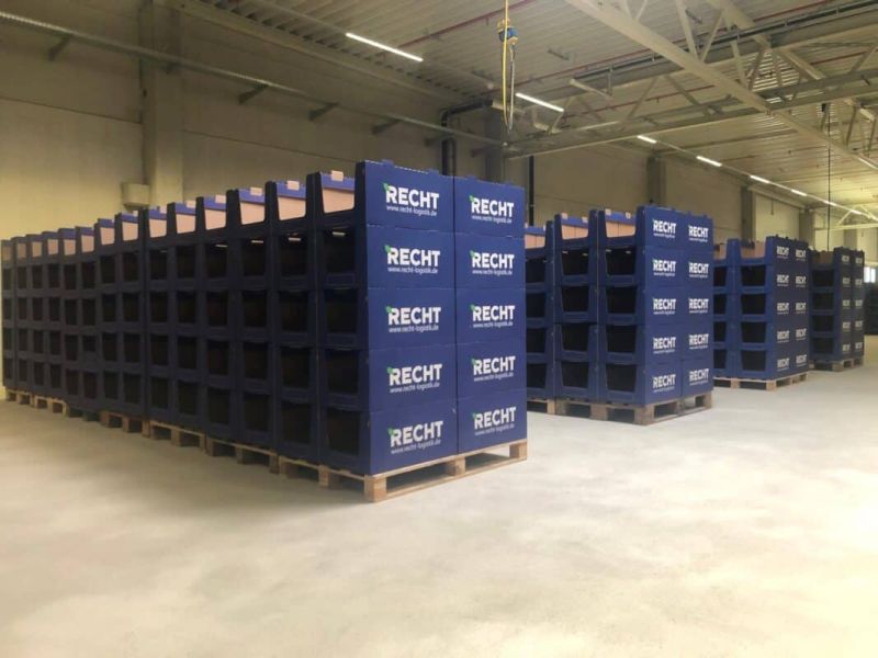 Palletized stacks of branded pick bins on a warehouse floor
