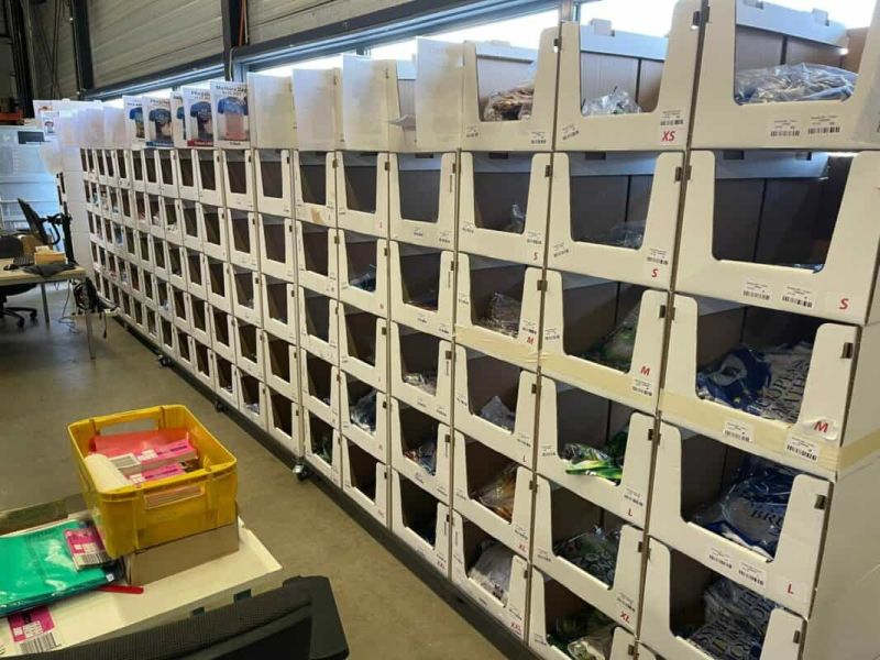 Stacked white pick bins labelled by size on a mobile warehouse pick face